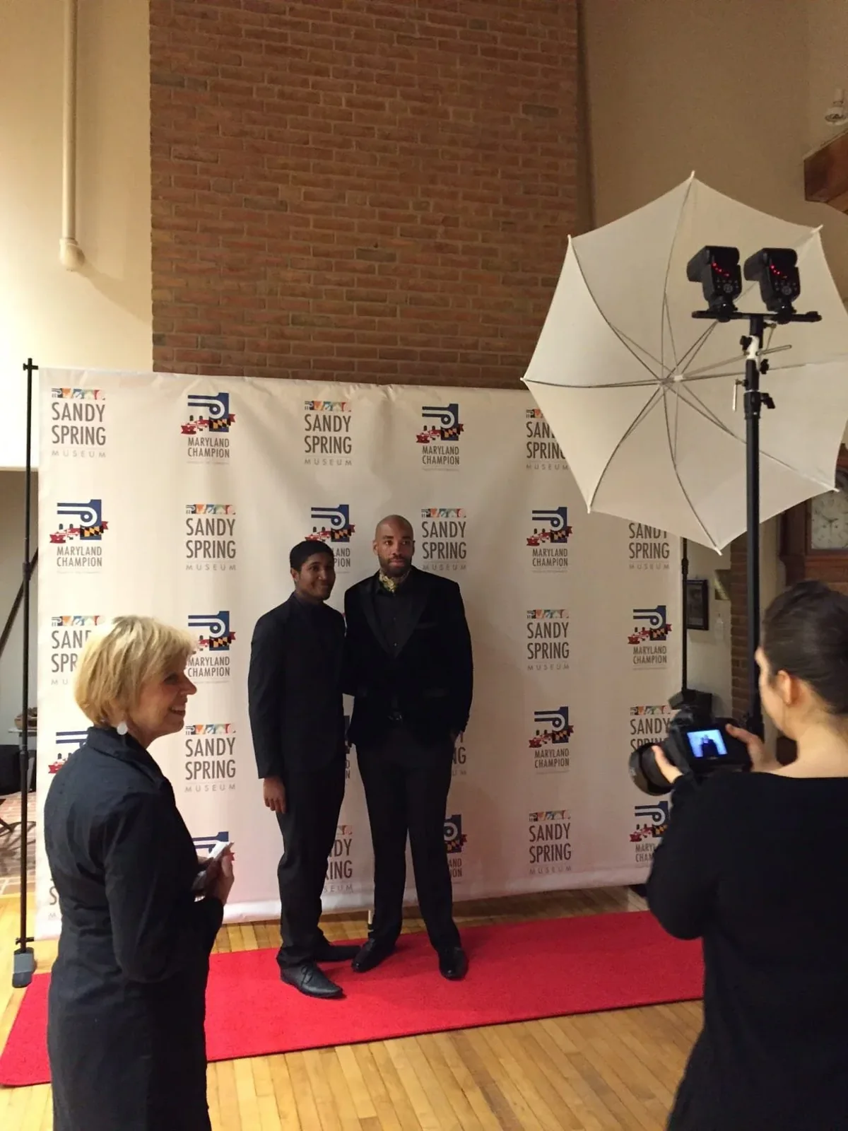 Guests being photographed on a red carpet at a museum event