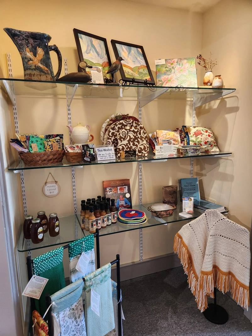 Shelves displaying handmade gifts and paintings