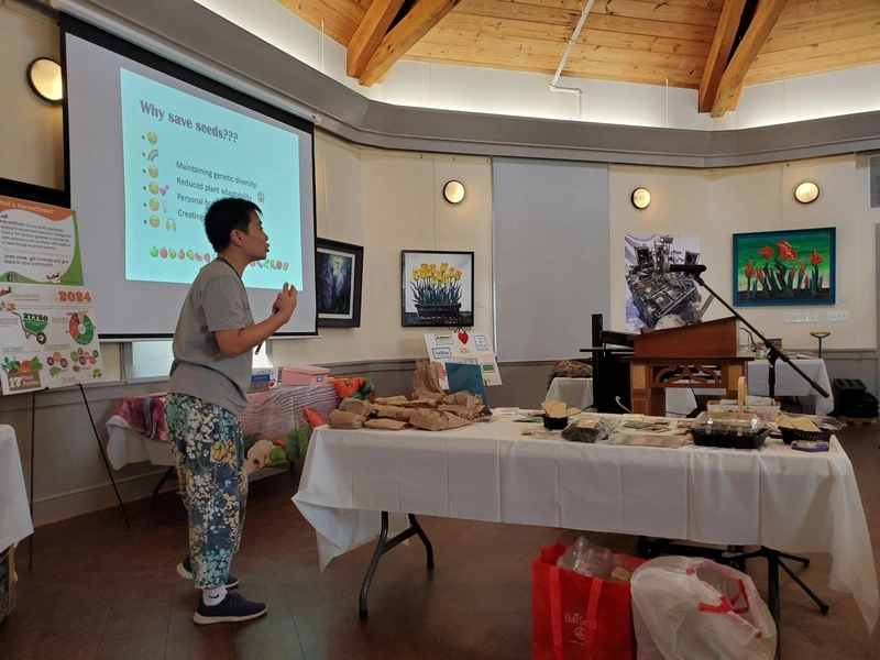 A Garden Club presenter speaking beside a projected slide.