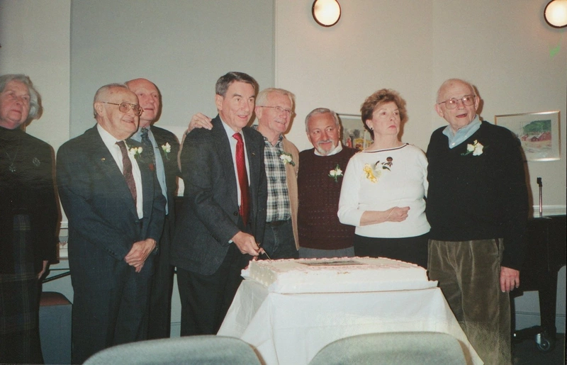 Sandy Spring Museum community members gather around a cake at the museum’s 25th anniversary celebration.