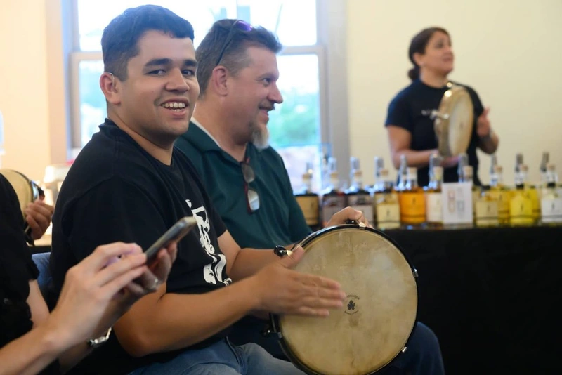 People participating in a group music activity, playing tambourines