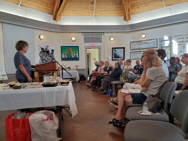 Garden Club participants seated around a workshop demonstration table.